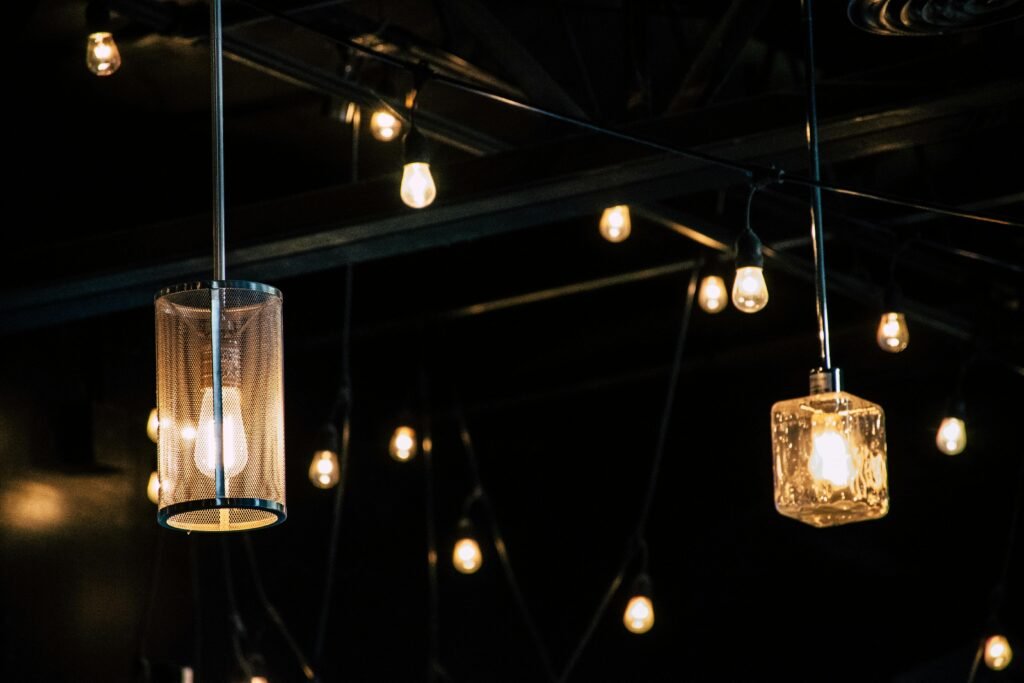Close-up of decorative hanging light bulbs illuminating a dark interior space.